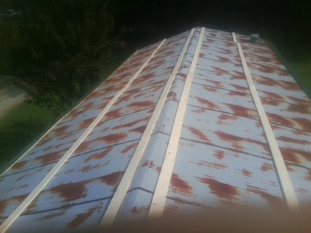 Rusted metal roof panels with new wood purlins before replacement — Storm Damage Roof Repair in Bloomfield by Roofing Brothers